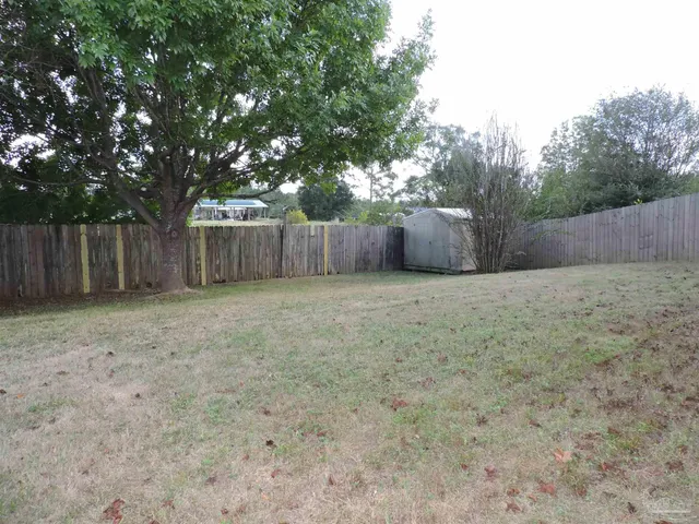 a view of a backyard with wooden fence