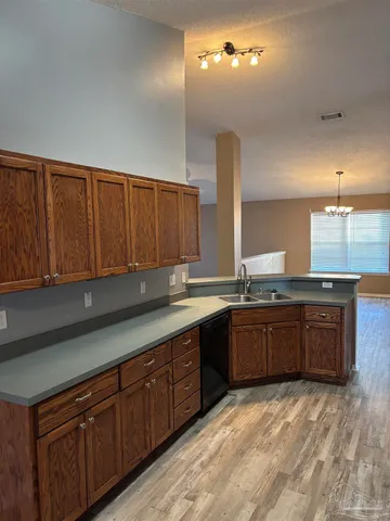 a large kitchen with granite countertop a sink and dishwasher wooden cabinets with a granite countertops