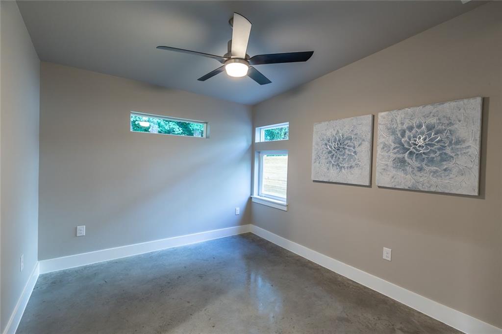 1142 Eleanor Street, Unit 2 Austin, TX 78721 - Photo 19 of 24 Natural light filters into this well-lit room featuring concrete flooring and a modern ceiling fan.