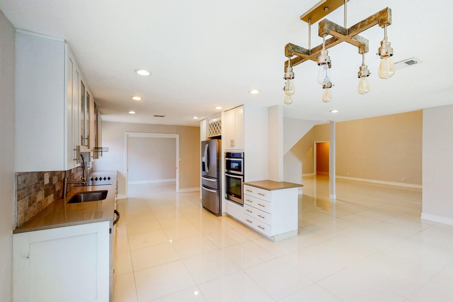 1339 Southwest 3rd Street Boca Raton, FL 33486 - Photo 13 of 56 a open kitchen with cabinets a sink and a stove