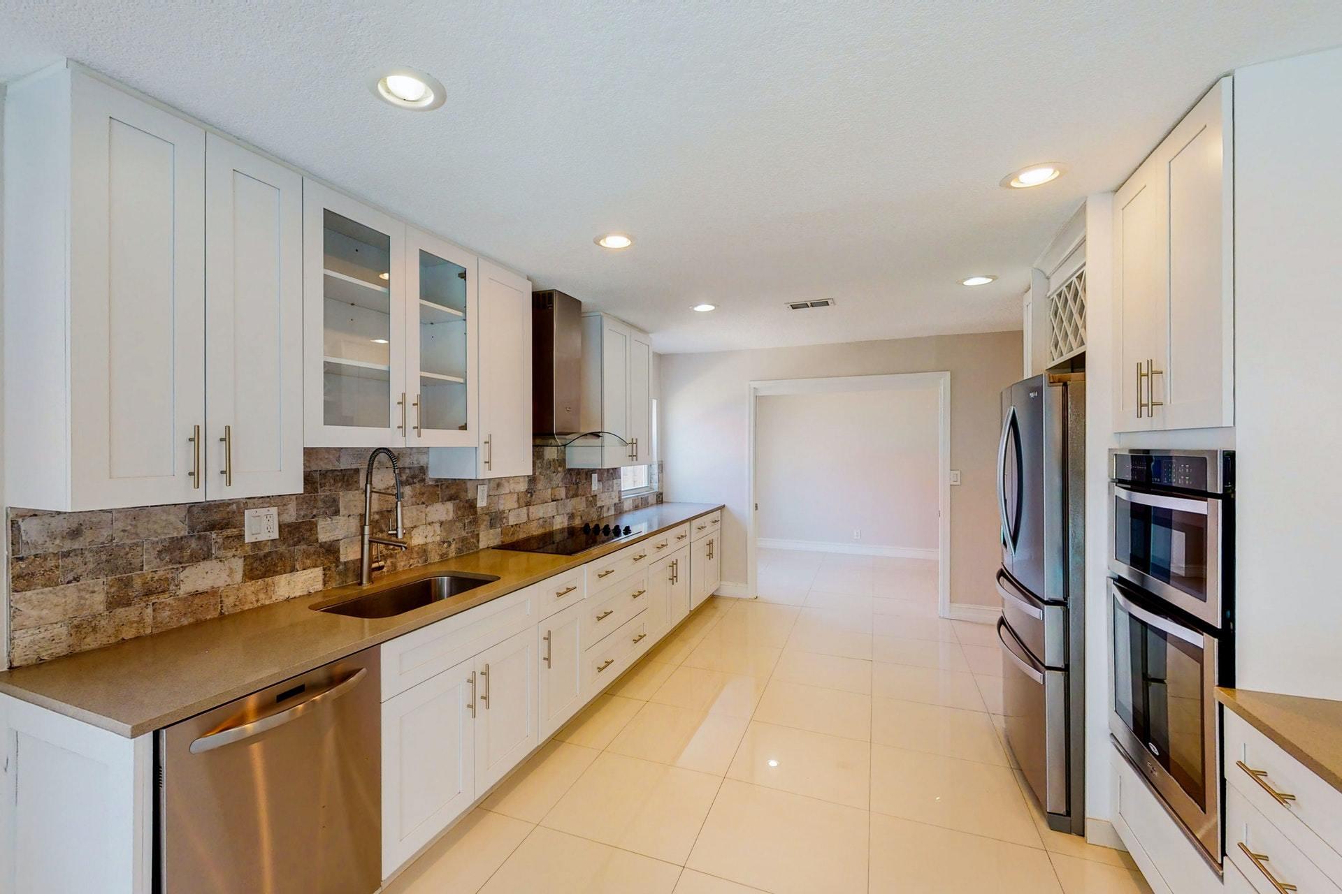 1339 Southwest 3rd Street Boca Raton, FL 33486 - Photo 14 of 56 a kitchen with stainless steel appliances granite countertop a refrigerator and a sink