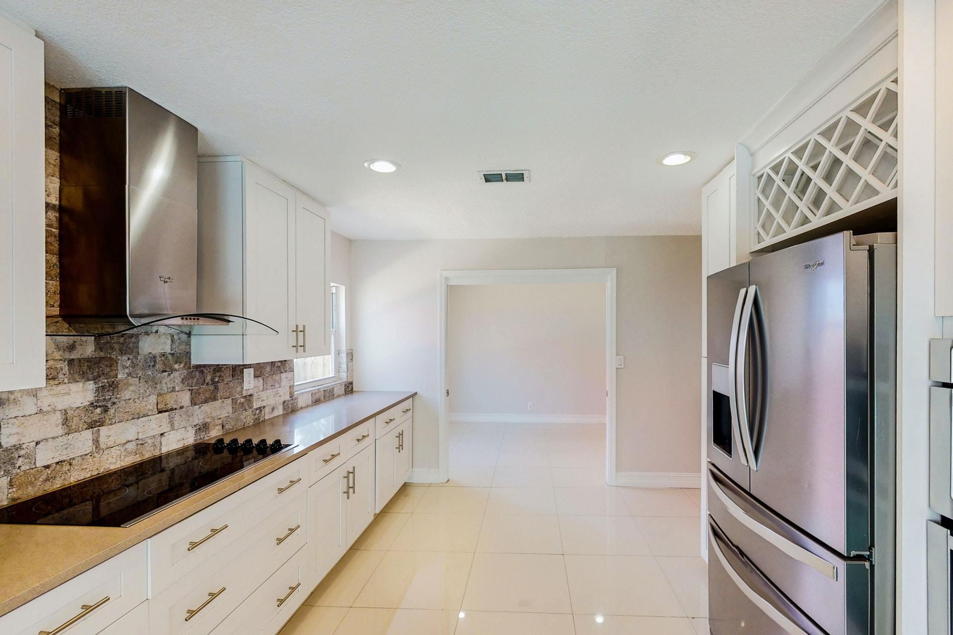 1339 Southwest 3rd Street Boca Raton, FL 33486 - Photo 15 of 56 a kitchen with stainless steel appliances granite countertop a refrigerator and a sink