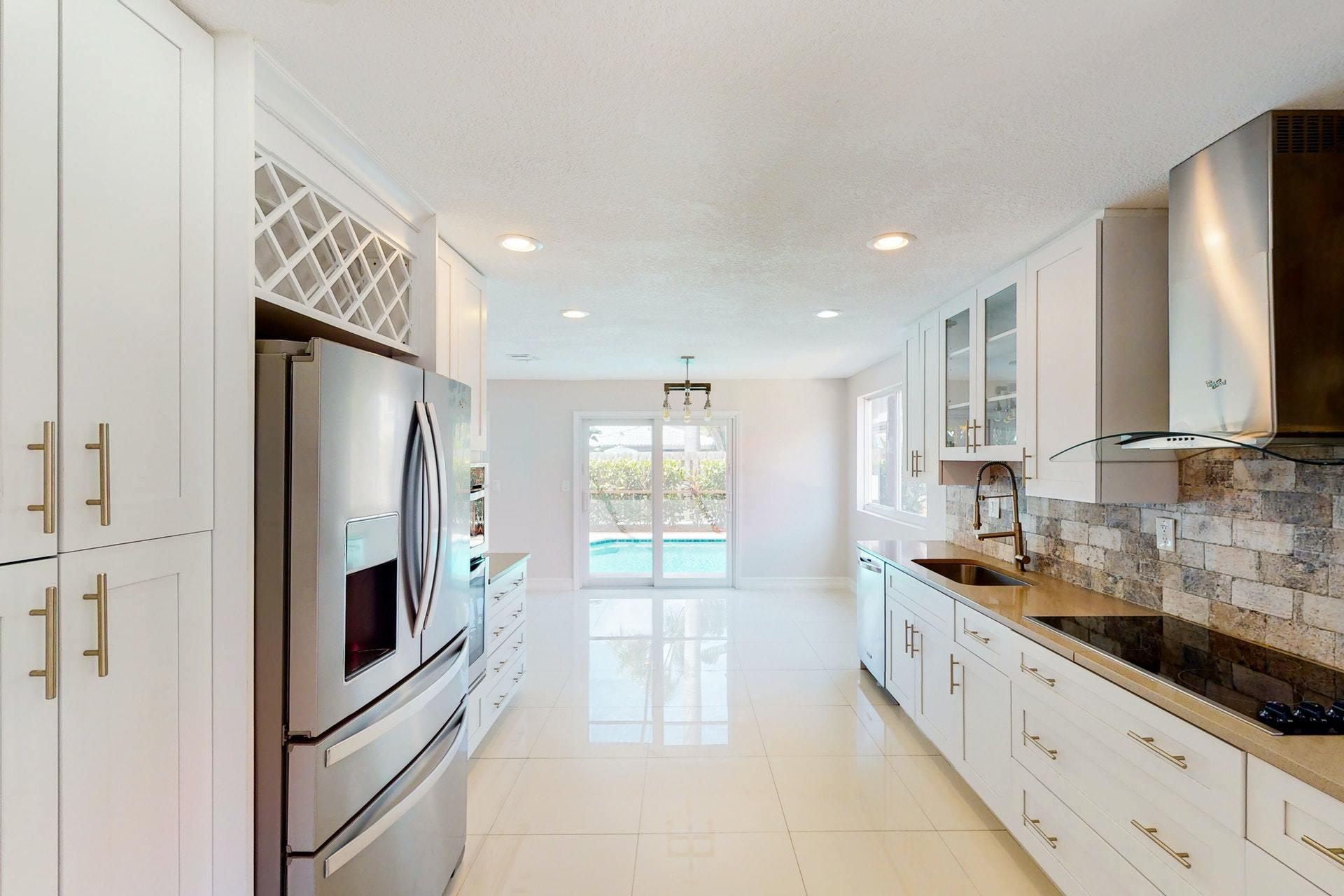 1339 Southwest 3rd Street Boca Raton, FL 33486 - Photo 16 of 56 a kitchen with stainless steel appliances granite countertop a refrigerator and a sink