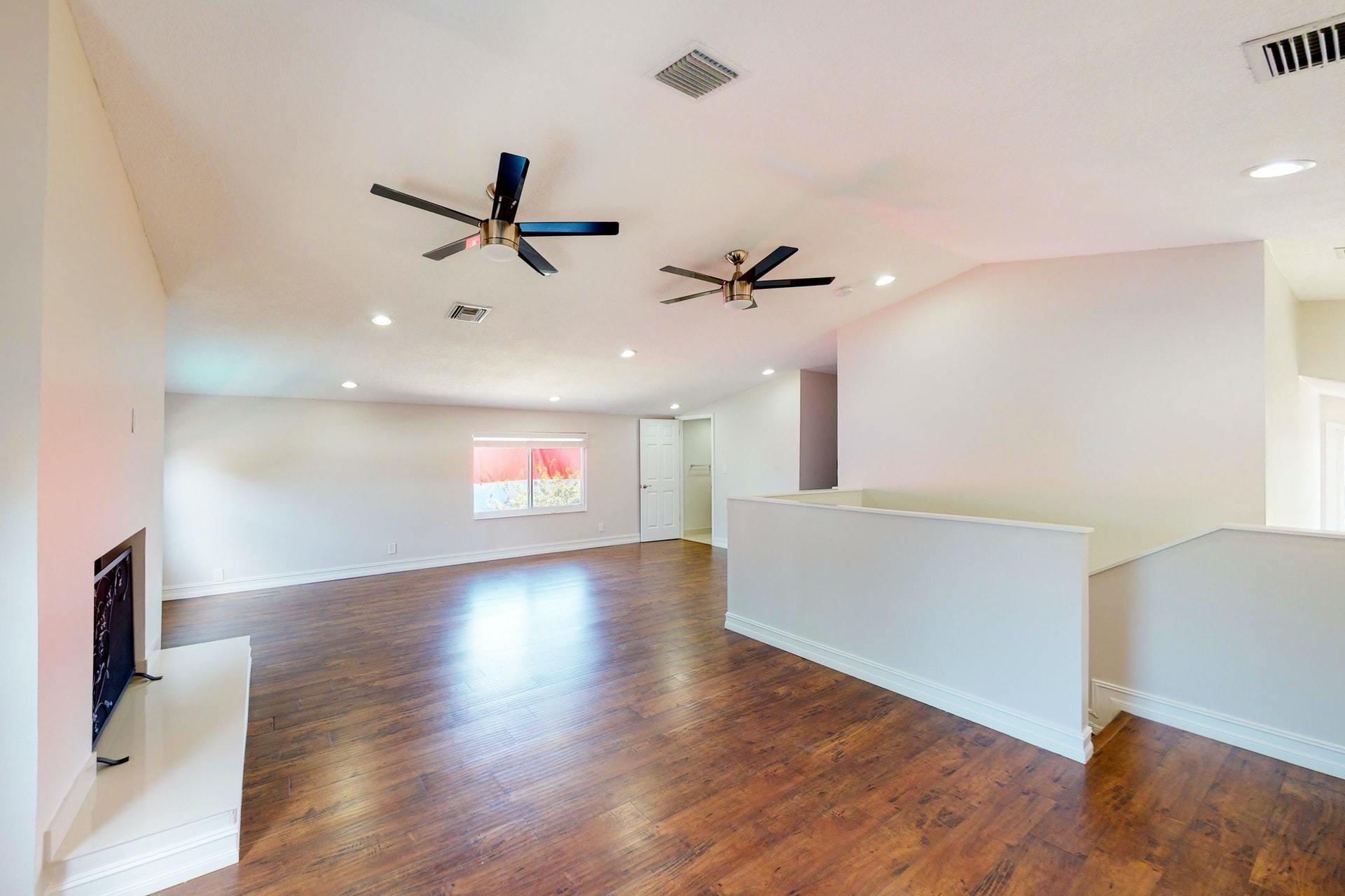 1339 Southwest 3rd Street Boca Raton, FL 33486 - Photo 37 of 56 a view of an empty room with wooden floor and a ceiling fan