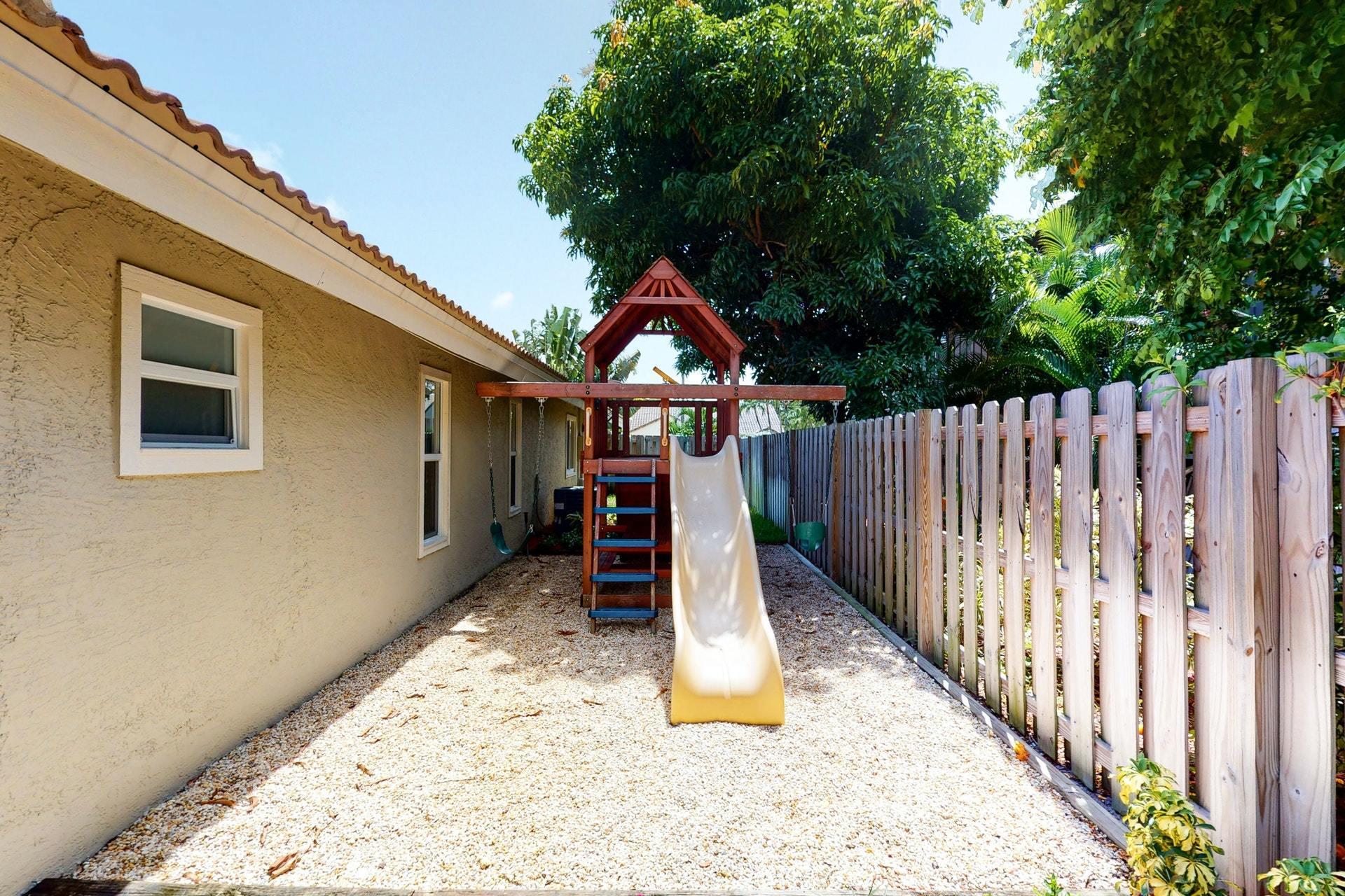 1339 Southwest 3rd Street Boca Raton, FL 33486 - Photo 52 of 56 a view of a house with wooden fence and a trees