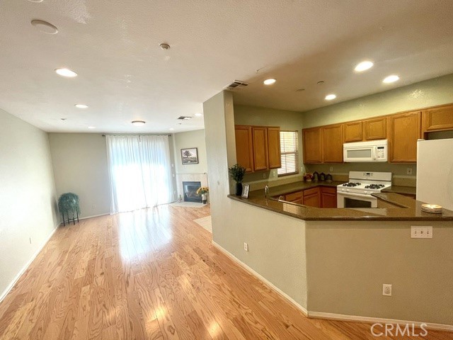 8692 East 9th Street, Unit 56 Rancho Cucamonga, CA 91730 - Photo 13 of 34 a large kitchen with stainless steel appliances a large counter top a stove a refrigerator with a sink