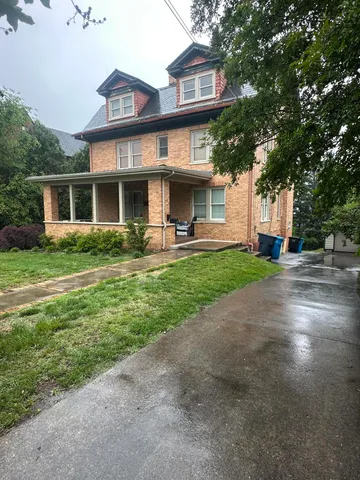 a front view of a house with a yard and trees