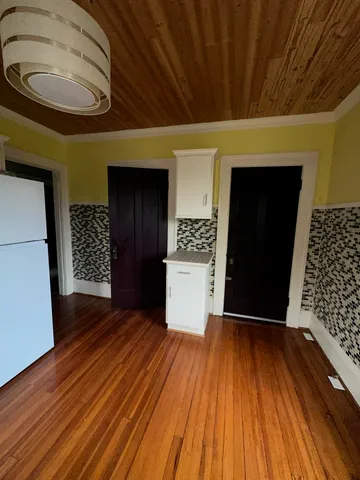 a view of a hallway with wooden floor and a large window