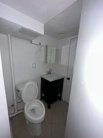 a bathroom with a toilet a sink and mirror