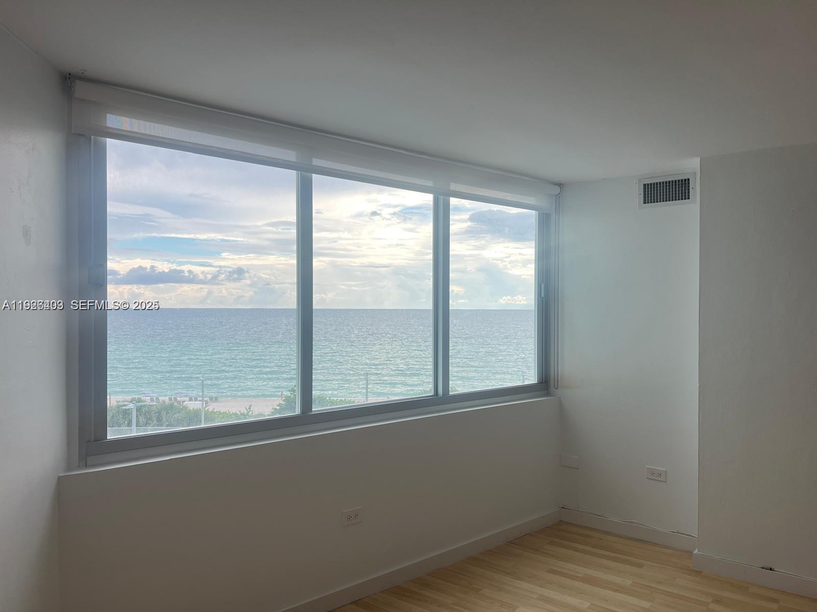 7135 Collins Avenue, Unit 512 Miami Beach, FL 33141 - Photo 3 of 10 a view of an empty room with wooden floor and a window
