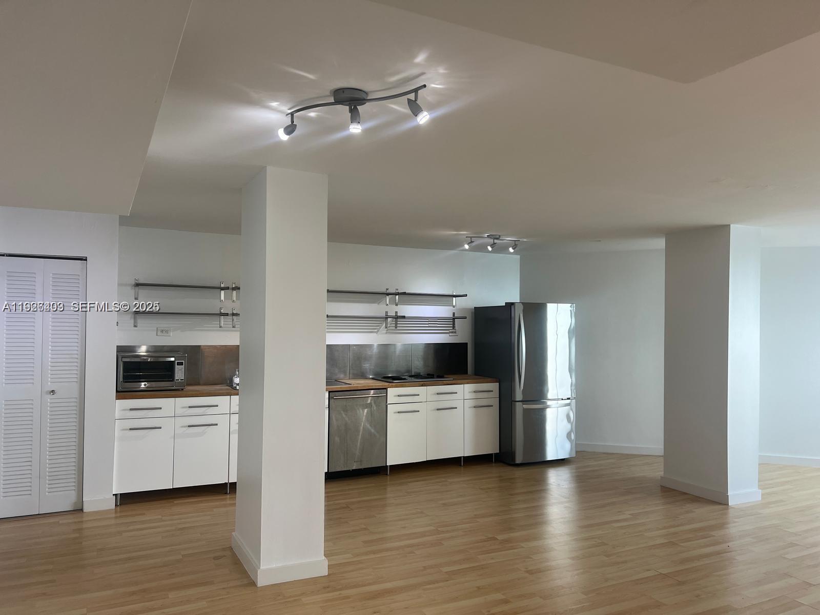 7135 Collins Avenue, Unit 512 Miami Beach, FL 33141 - Photo 5 of 10 a kitchen with cabinets and stainless steel appliances