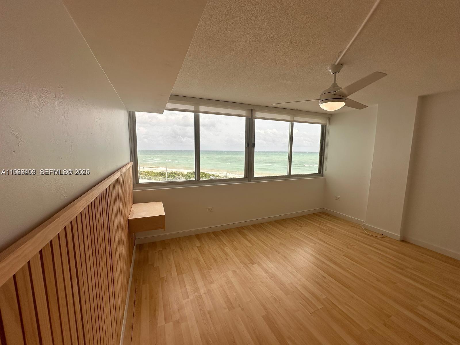 7135 Collins Avenue, Unit 512 Miami Beach, FL 33141 - Photo 8 of 10 an empty room with wooden floor and windows