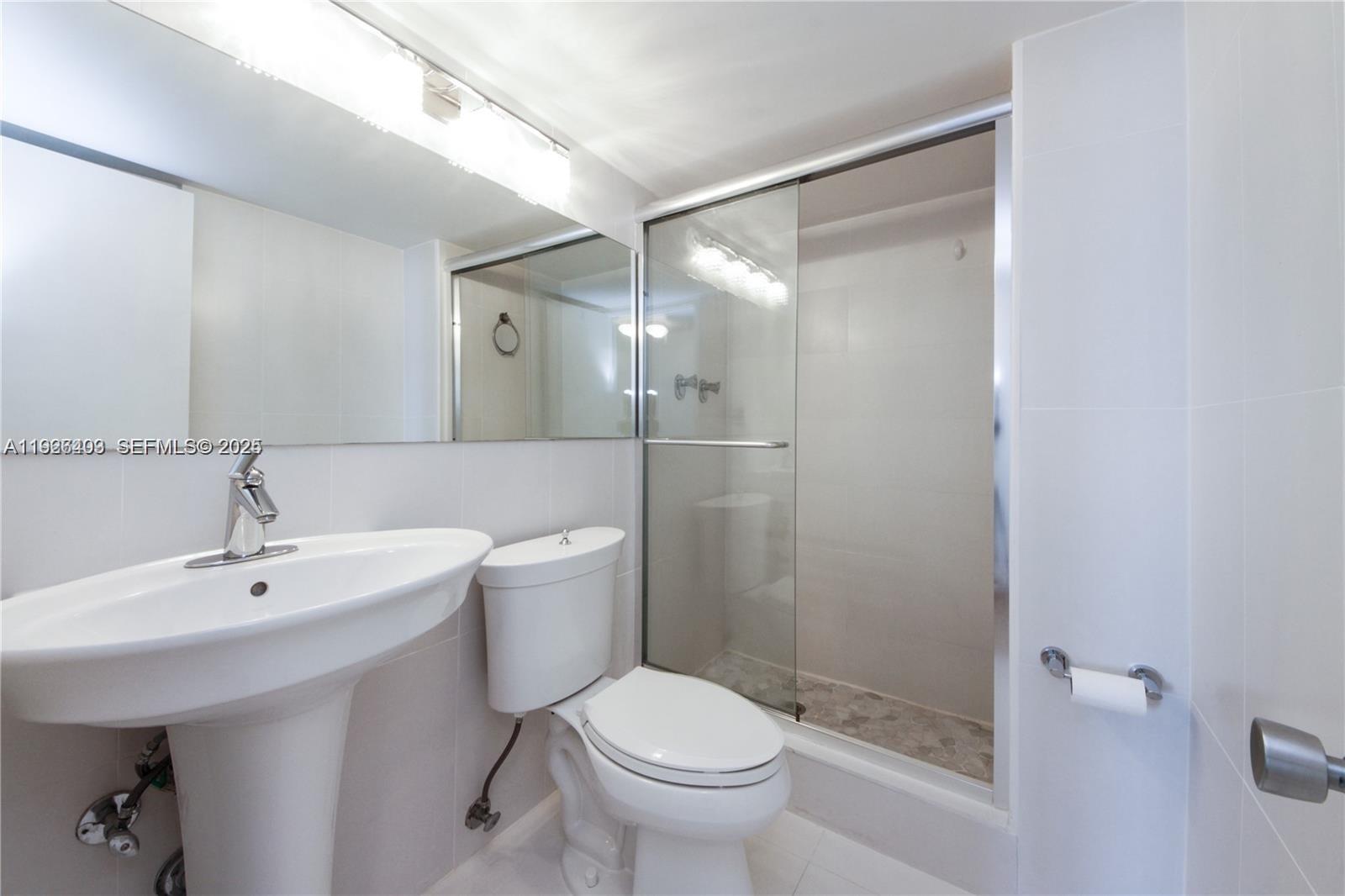 7135 Collins Avenue, Unit 512 Miami Beach, FL 33141 - Photo 10 of 10 a bathroom with a sink toilet and shower