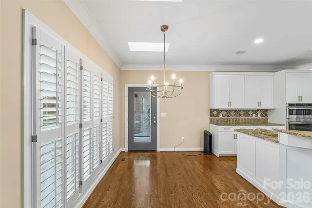 a view of empty room with wooden floor and fireplace