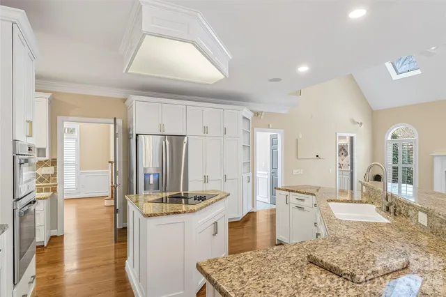 a kitchen with stainless steel appliances granite countertop a sink and cabinets