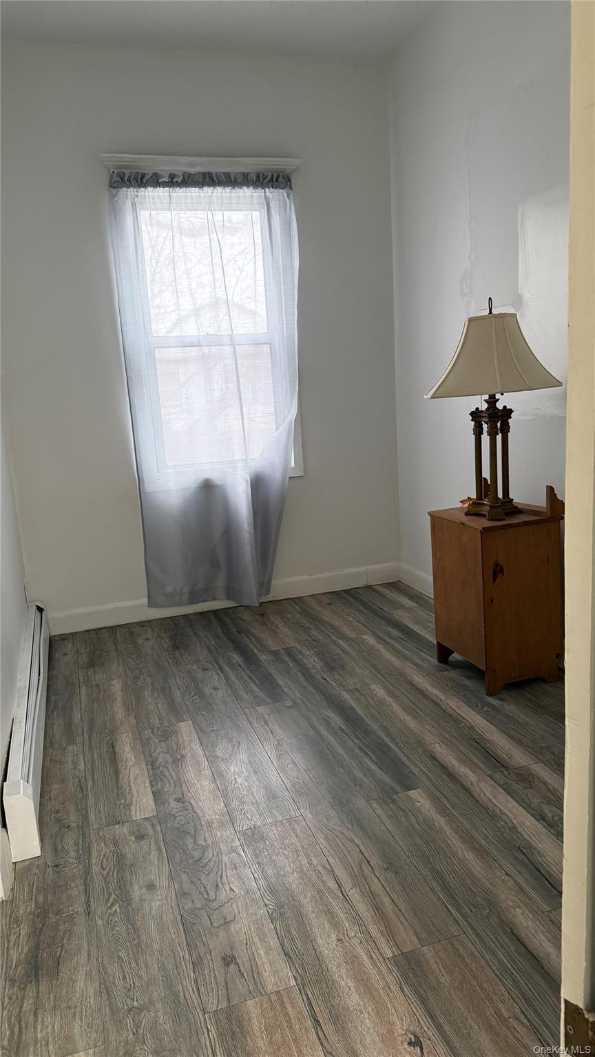 88-10 78th Street Queens, NY 11421 - Photo 17 of 19 an empty room with wooden floor table and windows