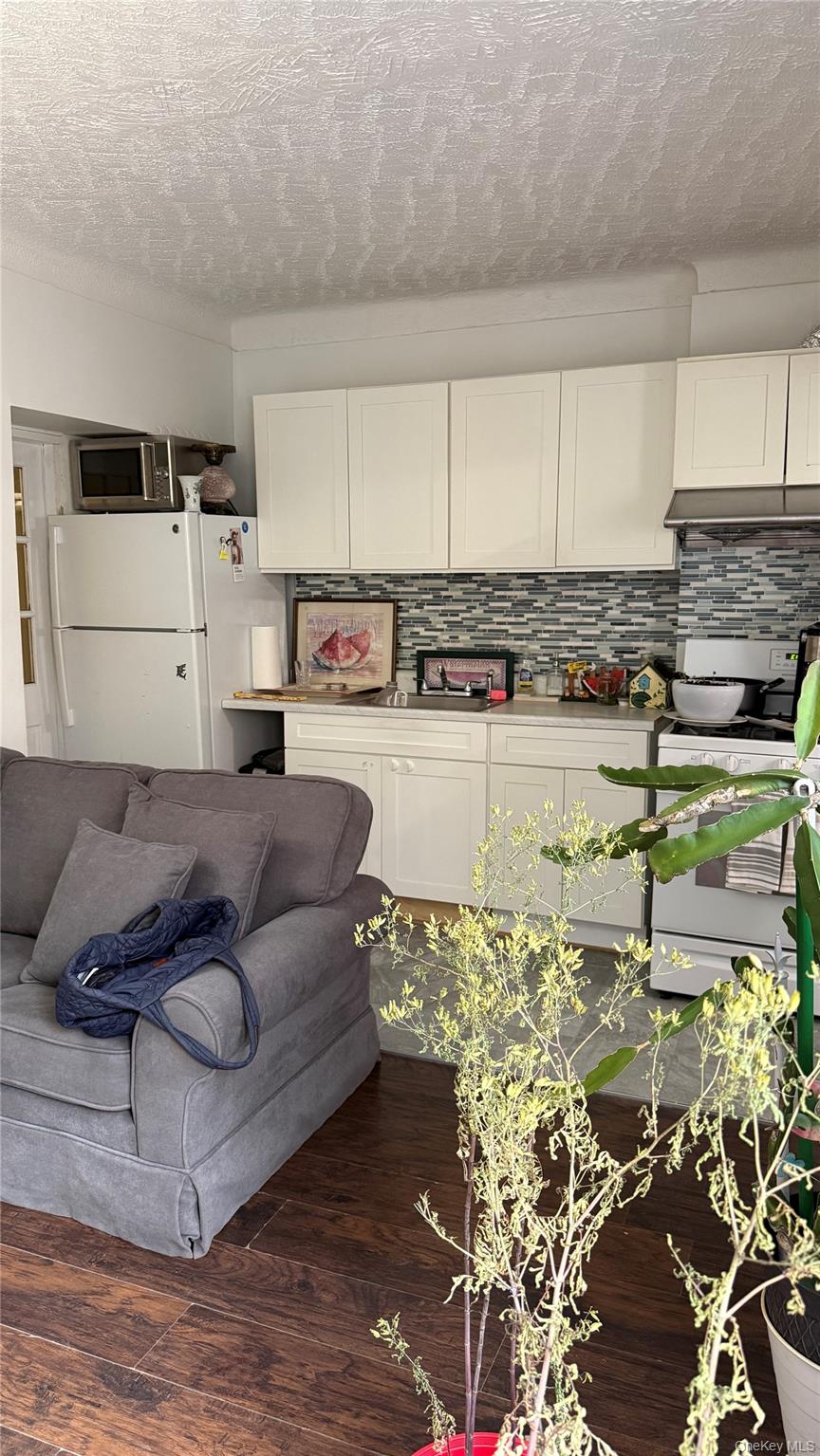 88-10 78th Street Queens, NY 11421 - Photo 6 of 19 a living room with furniture and kitchen view