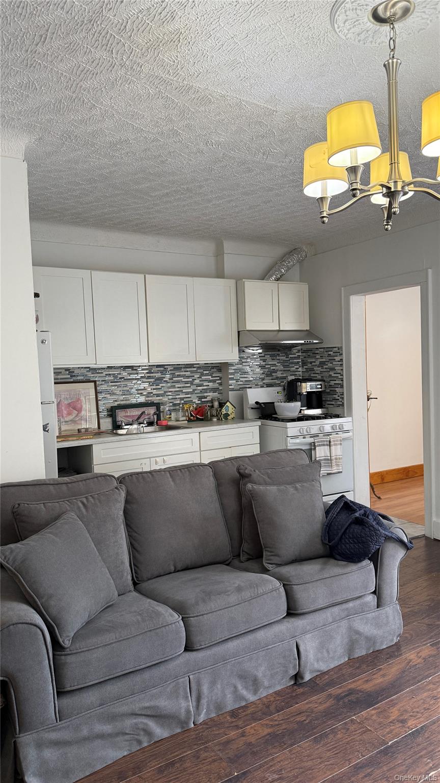 88-10 78th Street Queens, NY 11421 - Photo 7 of 19 a living room with stainless steel appliances kitchen island granite countertop furniture and a wooden floor