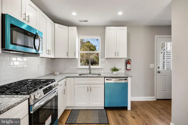 a kitchen with stainless steel appliances granite countertop a stove a microwave and a sink