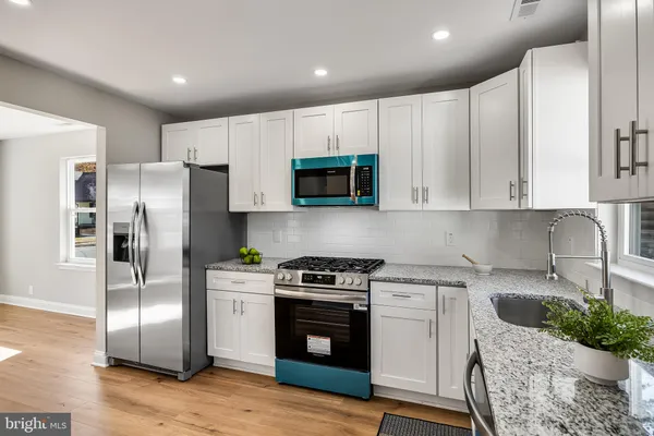 a kitchen with stainless steel appliances granite countertop a refrigerator stove a sink and a microwave