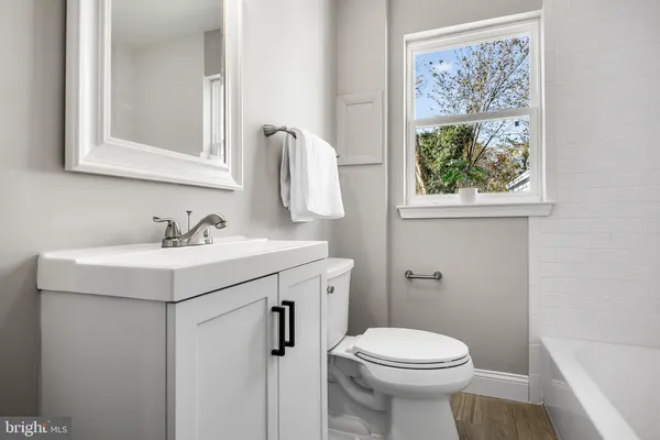 a bathroom with a sink mirror and toilet