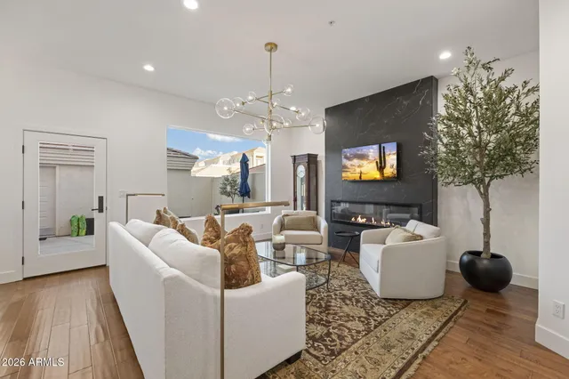 a living room with furniture a chandelier and a flat screen tv