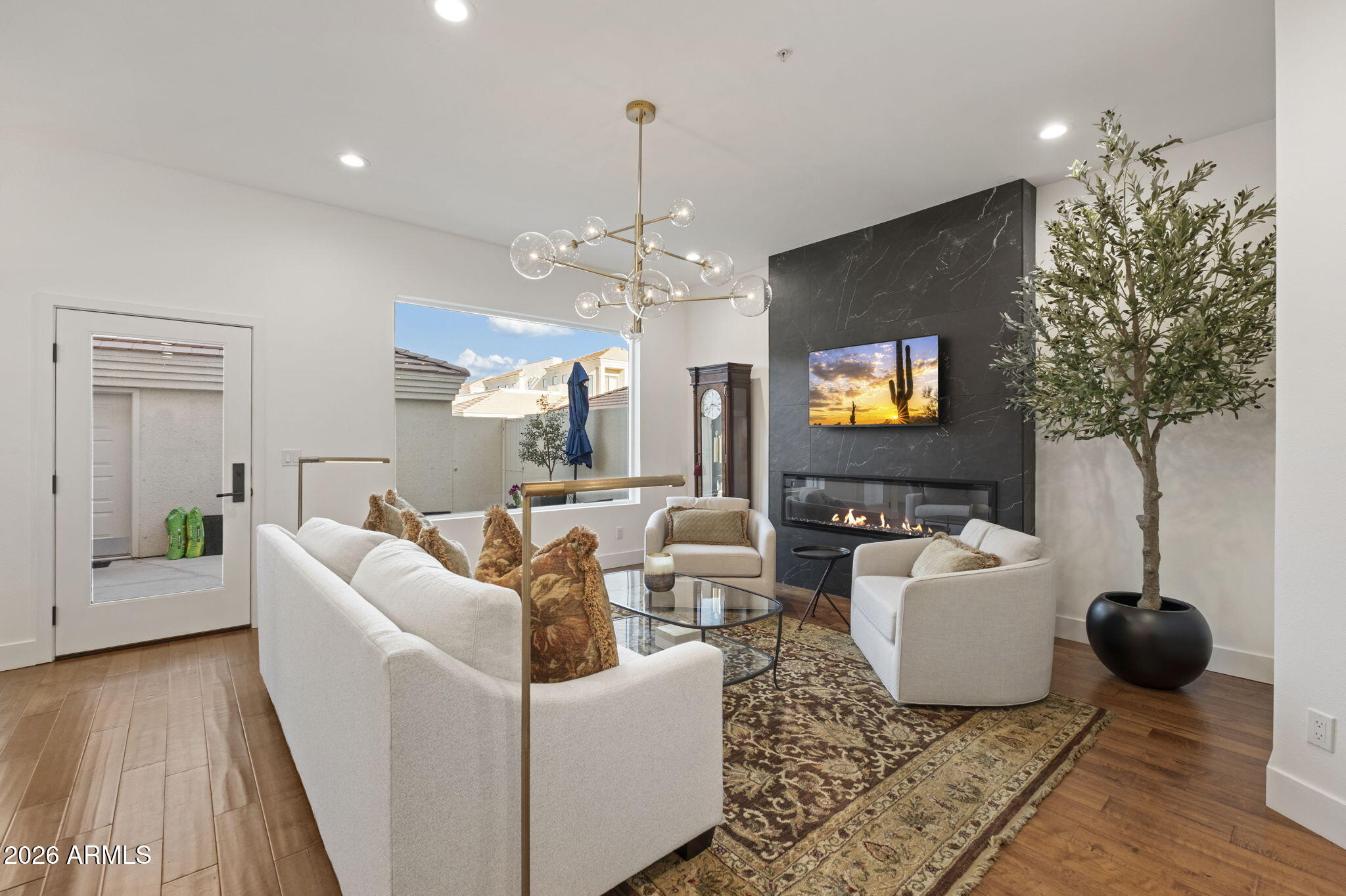8270 North Hayden Road, Unit 1036 Scottsdale, AZ 85258 - Photo 5 of 20 a living room with furniture a chandelier and a flat screen tv