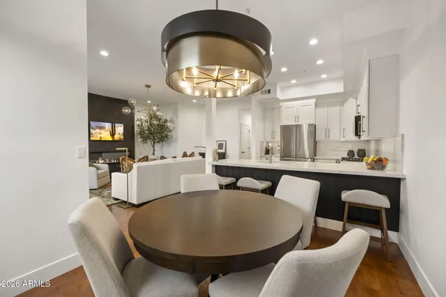 a living room with furniture a kitchen island and a chandelier