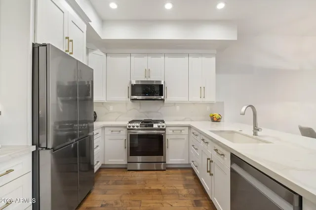 a kitchen with a sink appliances and cabinets