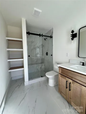 a bathroom with a sink a toilet and shower
