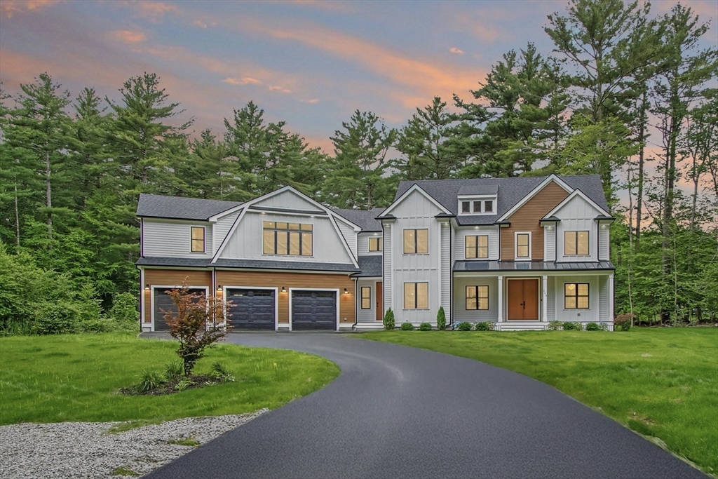 a front view of a house with a garden and trees
