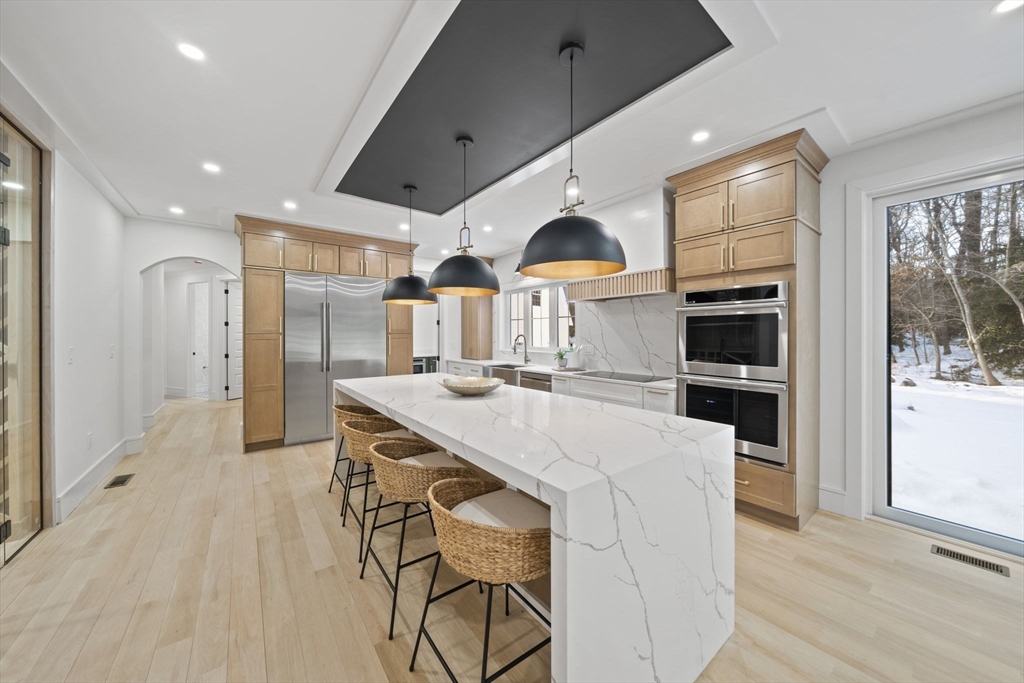 293 Cross Street Norwell, MA 02061 - Photo 4 of 42 a kitchen with stainless steel appliances kitchen island granite countertop a refrigerator and a stove top oven