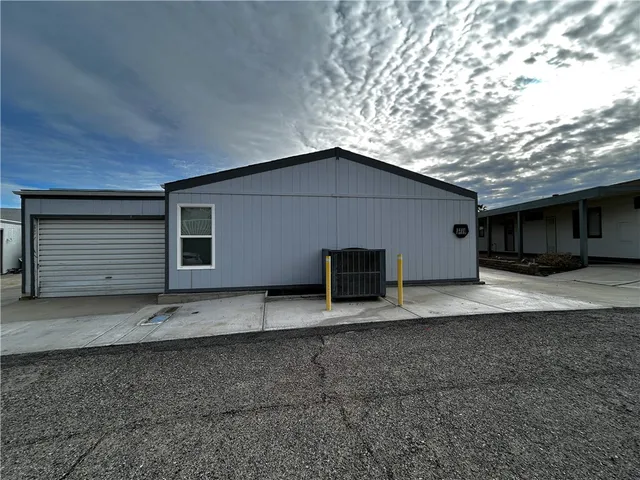 a view of house with backyard and parking