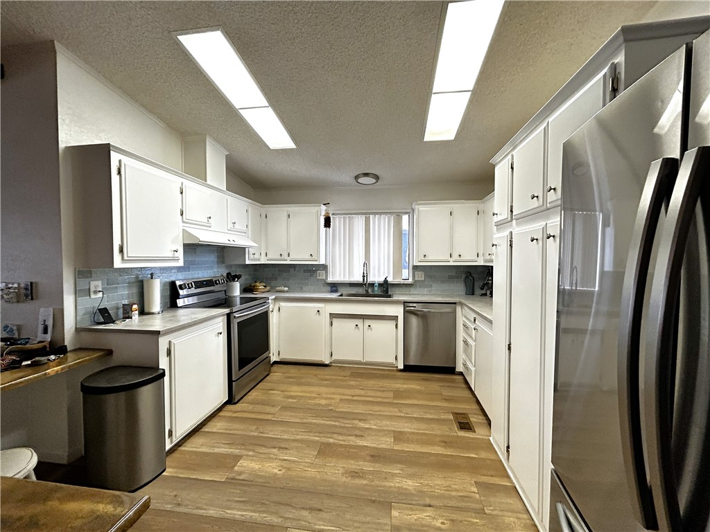 196 Thunderhead 2 Needles, CA 92363 - Photo 6 of 15 a kitchen with white cabinets and stainless steel appliances