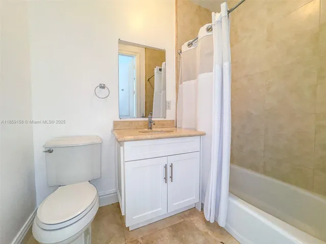 a bathroom with a granite countertop toilet a sink and a bathtub