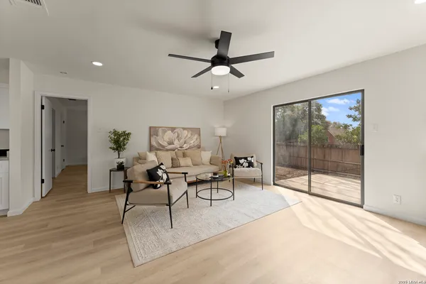 a dining room with wooden floor and a chandelier fan