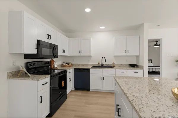 a kitchen with stainless steel appliances granite countertop a stove top oven a sink a microwave and refrigerator