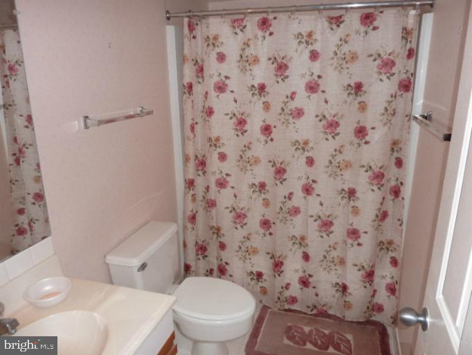 2903 Fallstaff Road, Unit 503 Baltimore, MD 21209 - Photo 17 of 20 a white toilet sitting next to a shower curtain