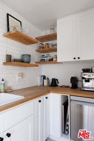 a kitchen with stainless steel appliances granite countertop a sink a stove and a microwave