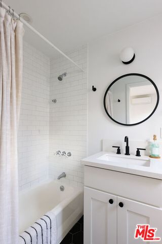 a bathroom with a sink a bathtub and a mirror
