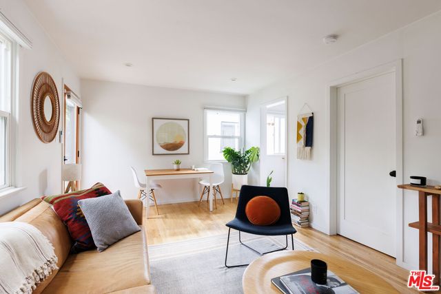 a living room with furniture a rug and a floor to ceiling window