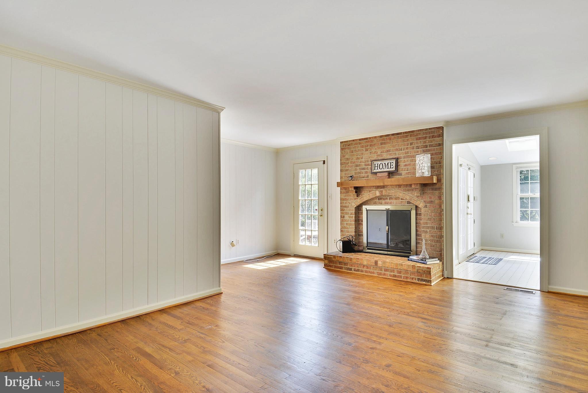 1026 Riva Ridge Drive Great Falls, VA 22066 - Photo 14 of 30 an empty room with wooden floor a fireplace and windows
