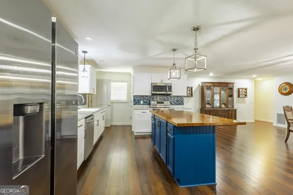 a kitchen with stainless steel appliances granite countertop a sink a stove and a wooden floors