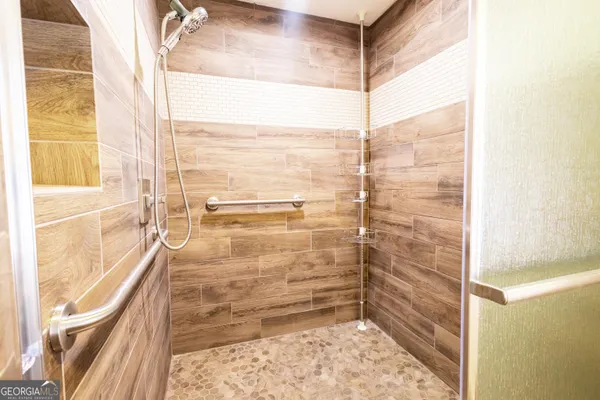 a bathroom with a granite countertop bathtub sink vanity mirror and toilet