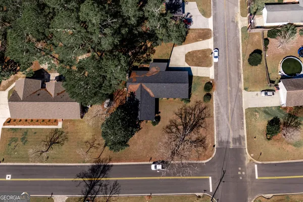 an aerial view of a house with a yard and large tree