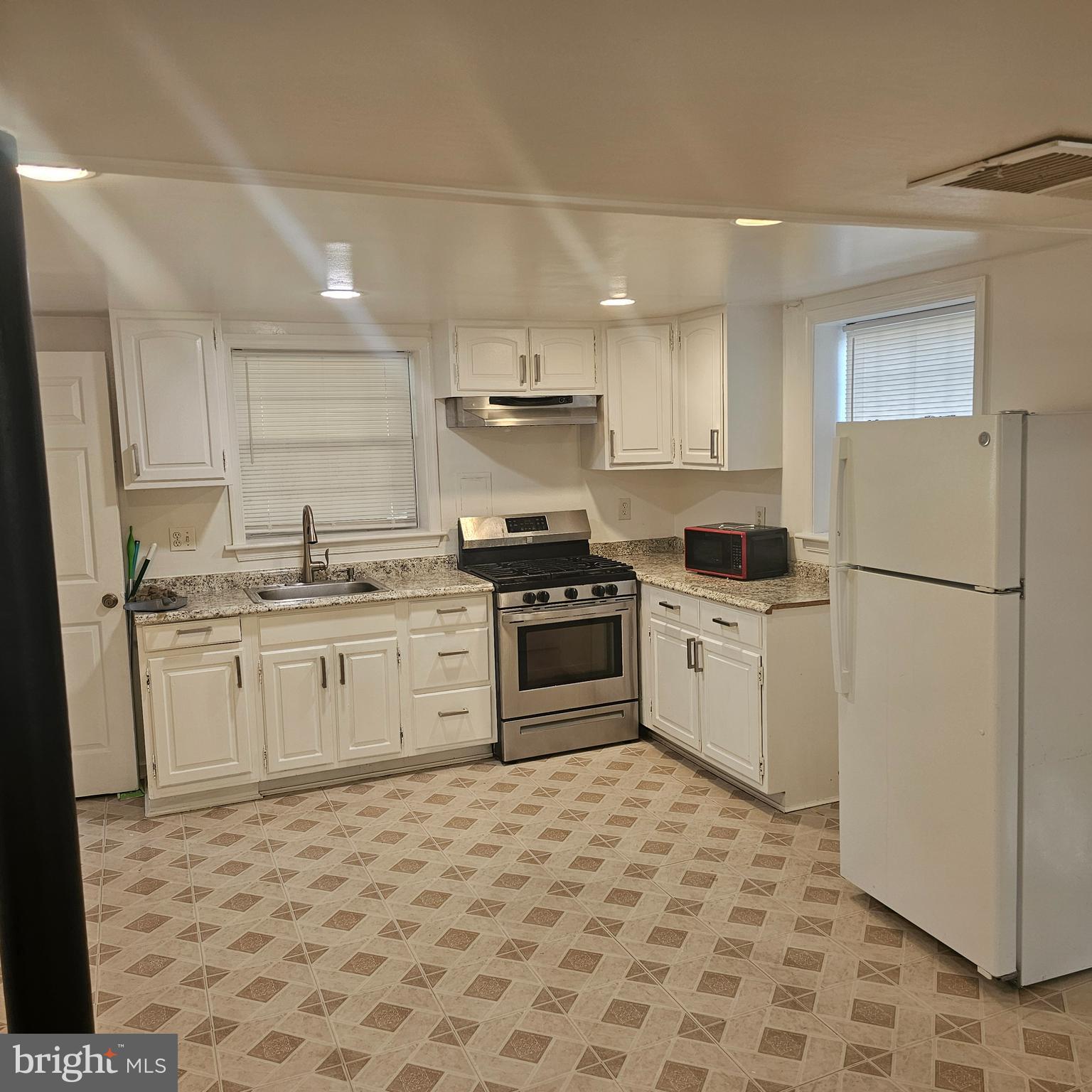 616 Hollywood Avenue Silver Spring, MD 20904 - Photo 8 of 9 a kitchen with a stove top oven a refrigerator and white cabinets