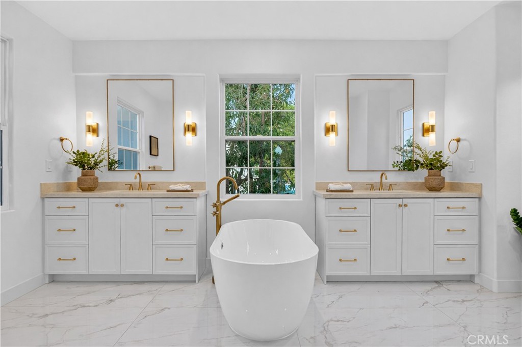 81 Zinnia Street Ladera Ranch, CA 92694 - Photo 23 of 47 a spacious bathroom with a granite countertop sink and a mirror