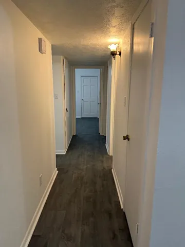 a view of a hallway with wooden floor