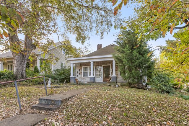 a front view of a house with a yard and potted plants