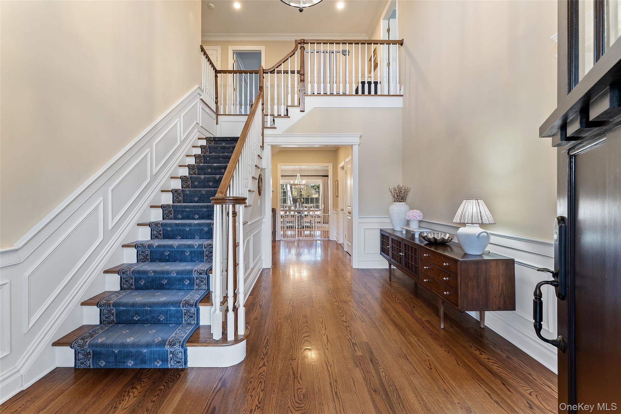 33 Wynmor Road Scarsdale, NY 10583 - Photo 3 of 40 Entry Foyer with gleaming hardwood floors and sweeping staircase with custom chair rail moldings